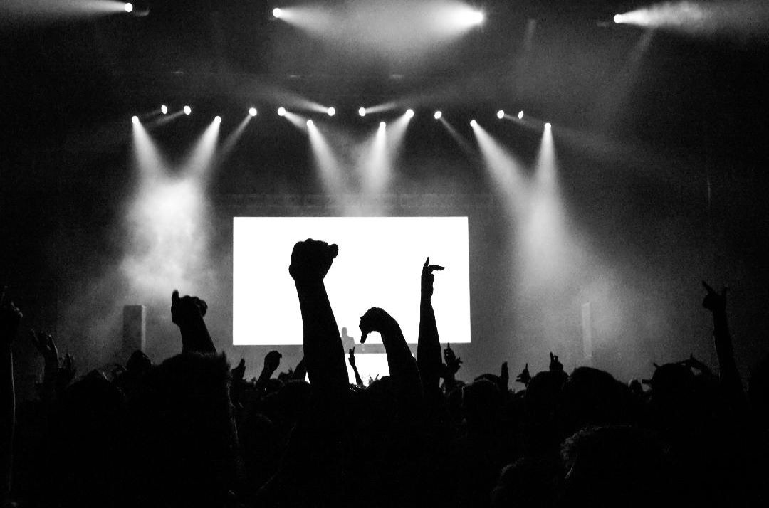 Black and white photo of crowd with hands in the air.