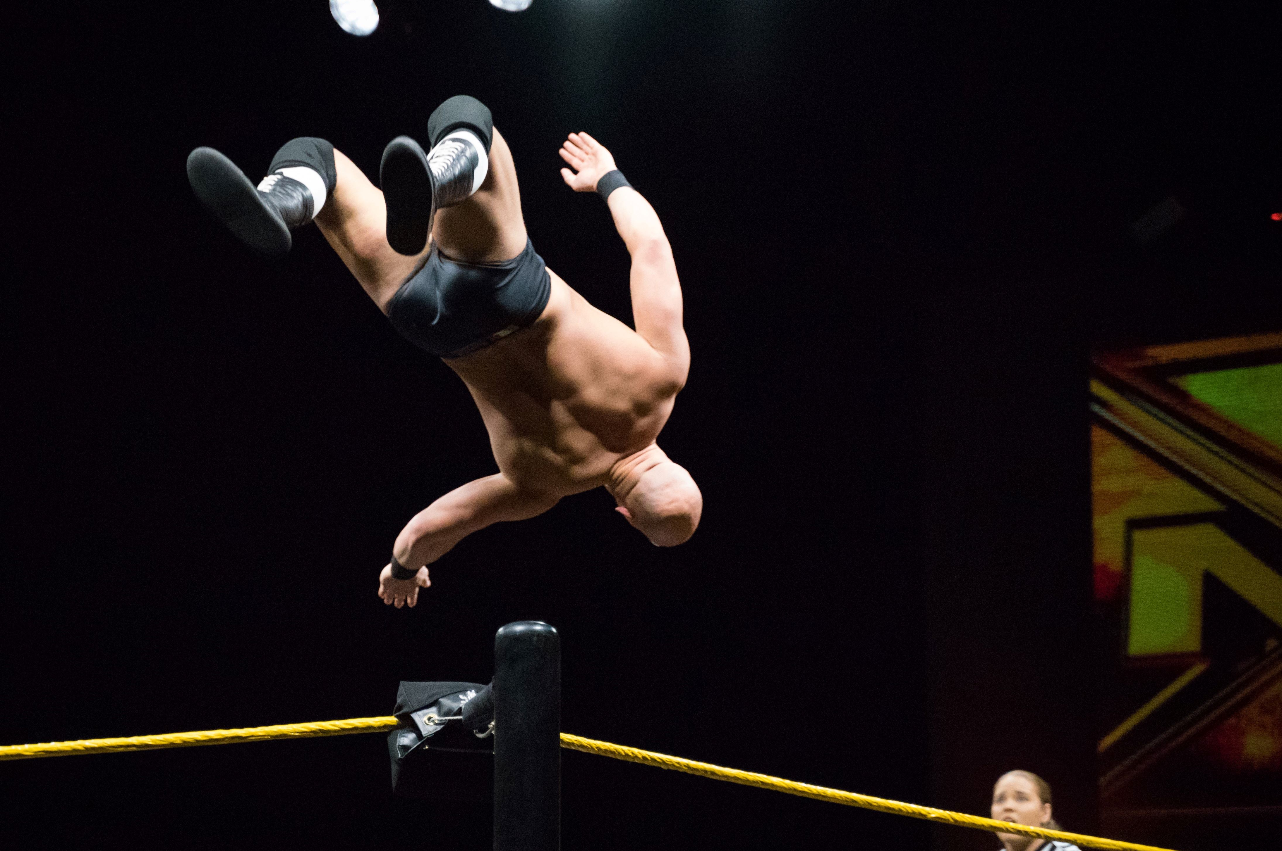 Wrestler doing a flip off corener post.